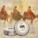 Candle tins labeled 'Sacred Journey' with a background of three wise men on camels.